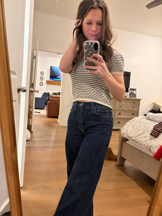 Woman with cableknit sweater and trouser jeans 